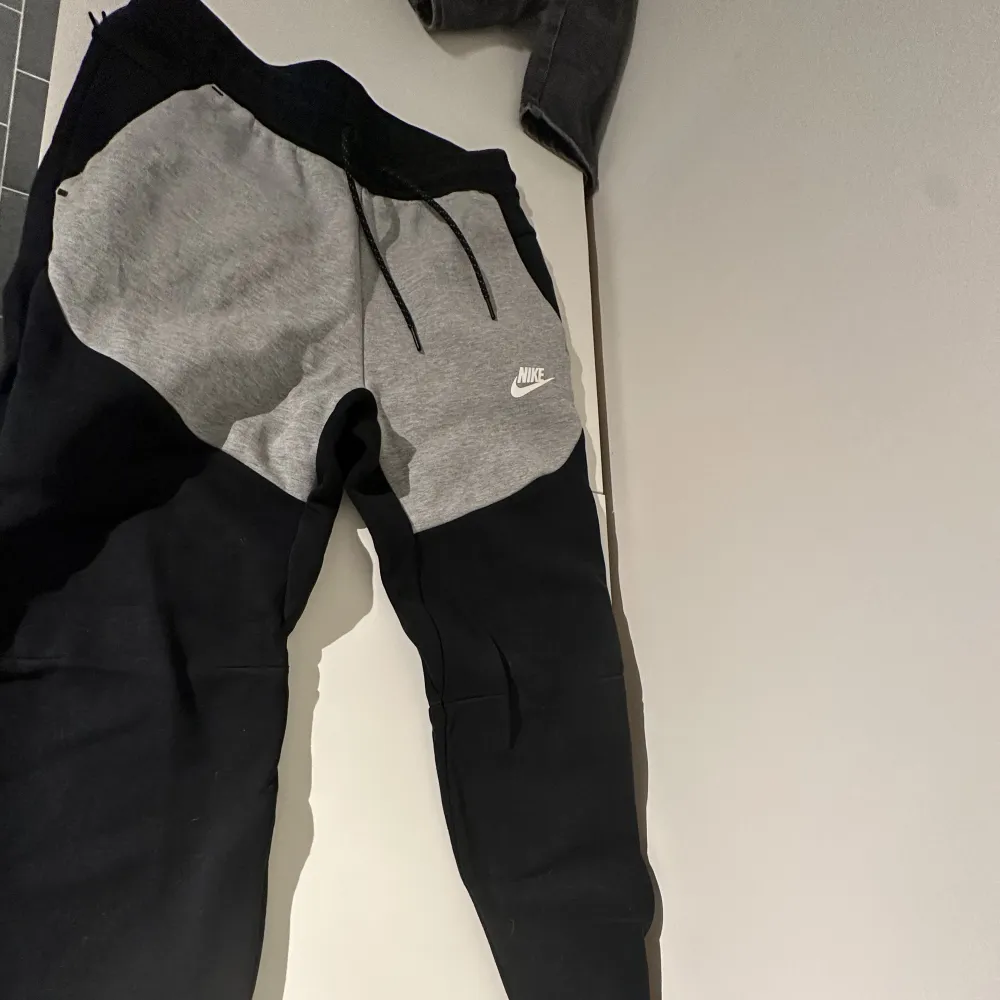 Nike tech flees byxor i färgen grå/svart. Köpta på Nike i Stockholm city.. Jeans & Byxor.