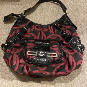 Fake Guees väska  - Fake Guees väska. Köpt secondhand. Ser lite mer röd ut på bilderna men den ä lite mer rosa 