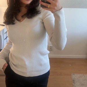 Tröja - Vit ribbad tröja med liten V-detalj vid halsen 