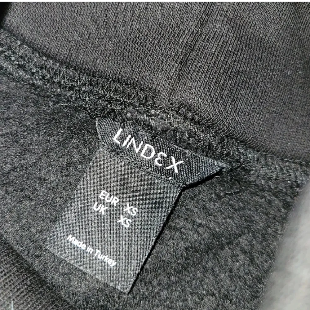 Svart kroppad sweatshirt med polokrage, från Lindex i storlek XS. Tjockt material och fodrad inuti. Endast använd 1 gång, så i utmärkt skick. Kan fraktas, men köparen står för frakten 🥰. Hoodies.