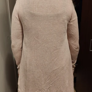 Kofta - Puderrosa mjuk och mysig kofta från Cubus. Längd ca 73 cm. Krage som viks ned. Något noppig men i stort sett i mycket fint skick. 55 % viskos, 25 %bomull och 20 % nylon.
