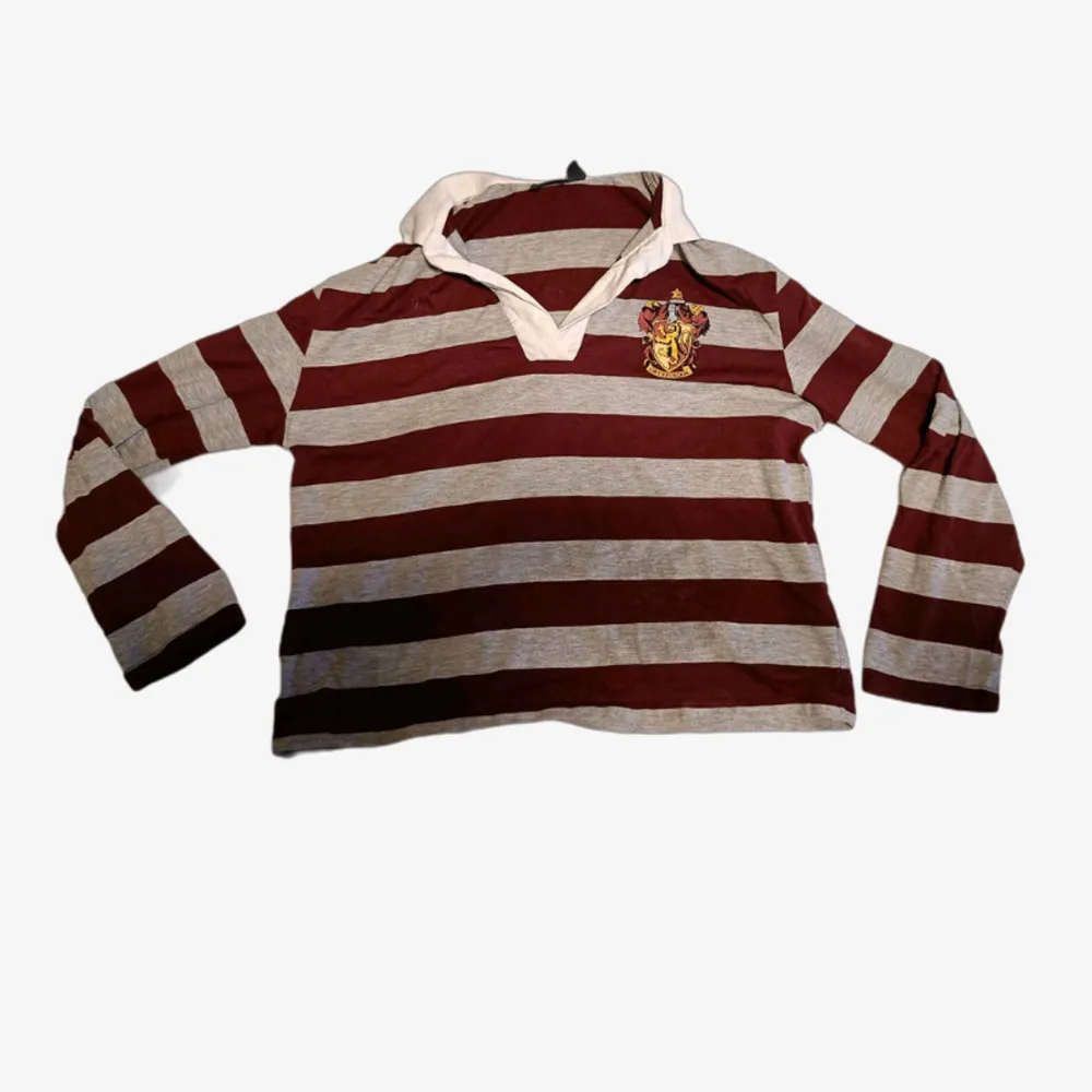 A red/white Gryffindor shirt in size (EUR) 34/36 (XS). It has a few spots on the collar but they're in the back and not noticable. I'm selling it because it's too small on me and I don't have the same interest in Harry Potter anymore.. Skjortor.