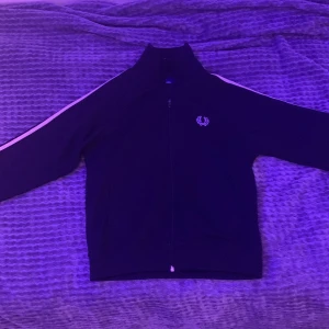 Fred Perry Taped Track Jacka - Säljer min Fred Perry taped track jacka, köpt för 1400kr. Den är använd men ändå i bra skick. Säljer på grund av att den tyvärr är för liten. 