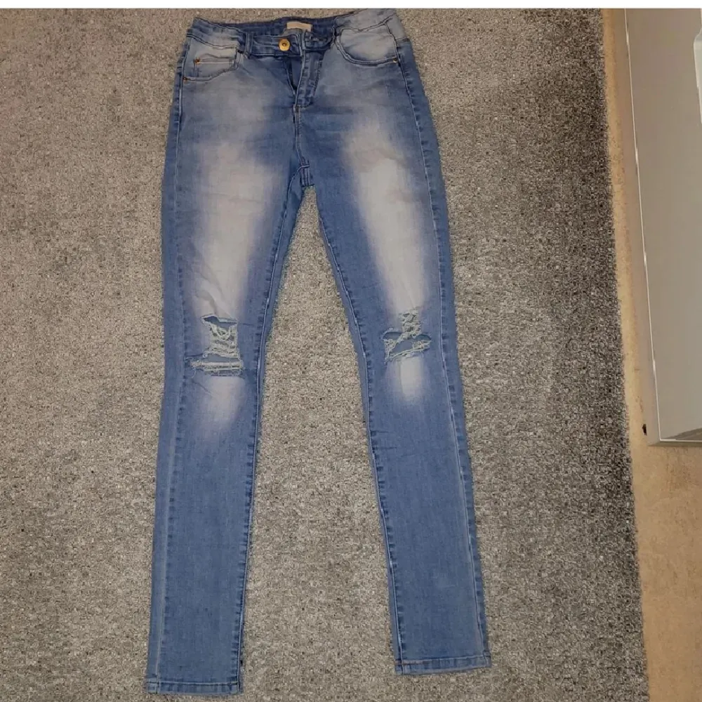 Blåa håliga jeans från KappAhl. Det står storlek 164, men skulle säga att den passar XS-S. Knappt använd, så i jättebra skick! Kan fraktas, men köparen står för frakten 🥰. Jeans & Byxor.