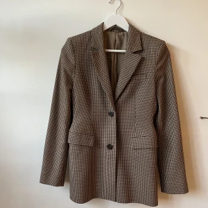 Kavaj från & Other Stories - Brunrutig figursydd kavaj som sitter så satans snyggt!! Storlek 34 från & Other Stories. Inget alls att anmärka på, den är inte använd så mycket! 