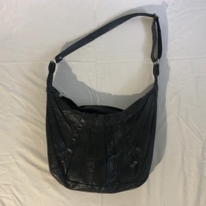 Svart läderväska - En så snygg svart läderväska med randiga detaljer, den är i äkta läder! Passar till allt och bandet går att justera