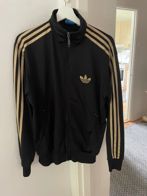 Adidas -zipjacket M - Fint skick Sparsamt använd Strl M Svart med guldränder 