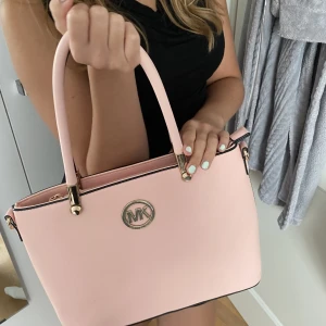Väska - Rosa Michael Kors väska i medium storlek. Knappt använd och rymmer mycket grejer. Ej äkta väska men fortfarande i super skick! Är flexibel om pris🙌