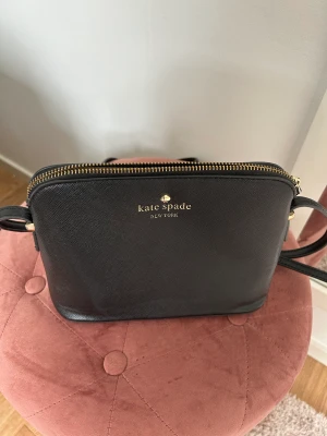 Crossbody väska  - Svart crossbody väska med guldiga detaljer. Justerbart band. 