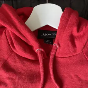 Säljer denna röda croppade hoodien från Monki som inte blivit använd. Fint skick!