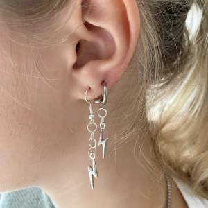 (Säljer för mitt UF) Flash Earrings Silver Long är ett par silvriga örhängen (den långa varianten) gjorda av rostfritt stål. Perfekta för att göra din outfit lite mer blixtrande. Vårt pris för dessa är endast 149 kr ?!
