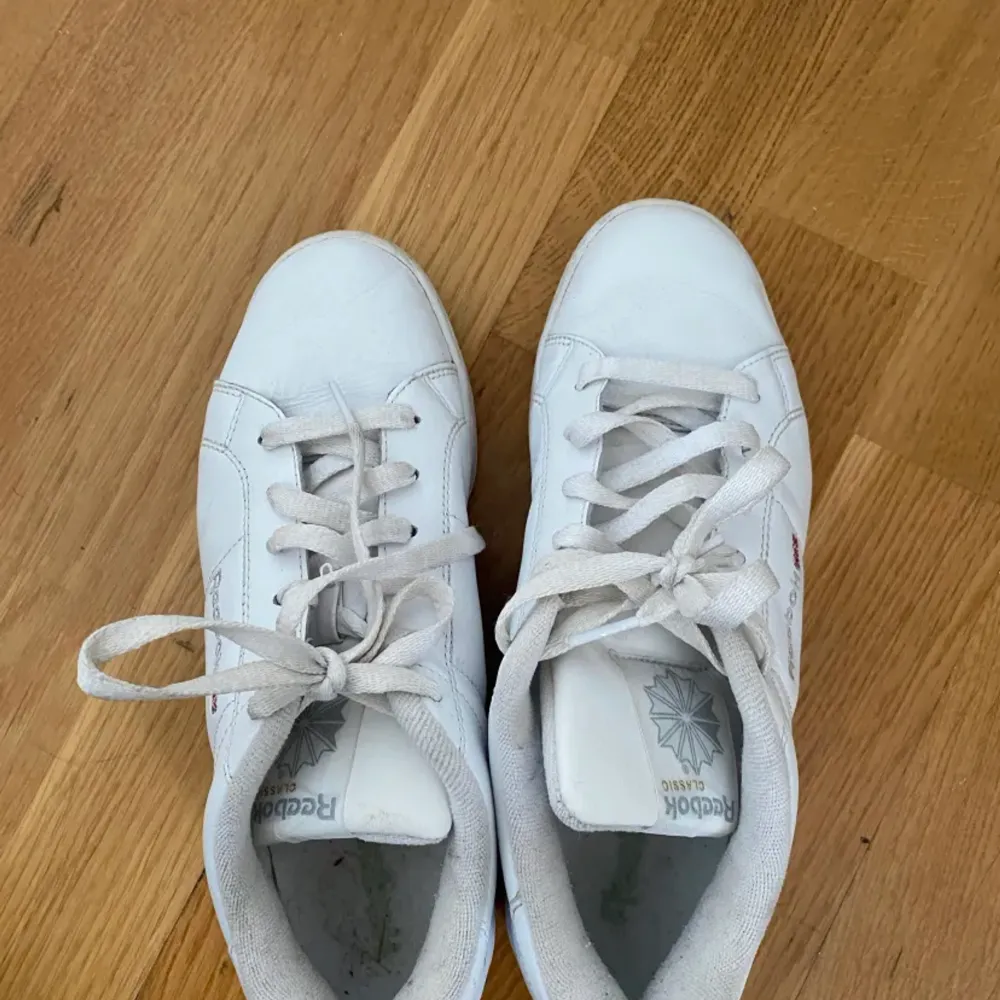 Säljer mina vita classic Reebok skor då de inte kommer till användning. Lite smuts på sulan och lite på sidan av skorna som syns på bilden men det går säkert att få bort. Storlek 39. Skor.