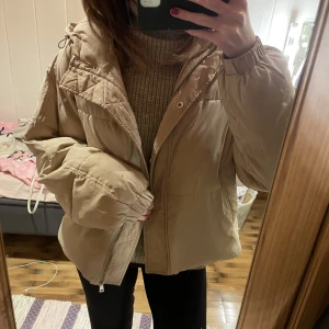 Pufferjacket - En beige oversized  vinterjacka ifrån NAKD i storlek S Den är använd 2 vintrar och har små fläckar vid ärmen (sista bilden) tror att de går att få bort med något slags medel 