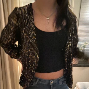 Glittrig trekvartsärmad kofta - Jätte fin glittrig kofta perfekt för nyår eller fest, aldrig använd perfekt skick, köpt utomlands därav vet jag inte märke eller storlek