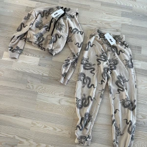 Mjukisset - Beige mjukisset från New Yorker med svarta drakar på. Lapparna finns kvar men inget kvitto! Ny pris: 378