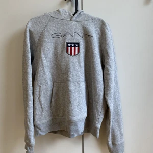 Gant hoodie  - En grå gant hoodie i storlek s/170. Knappt använd så den är som ny! Skickar gärna fler bilder vid förfrågan! Originalpris 1000kr