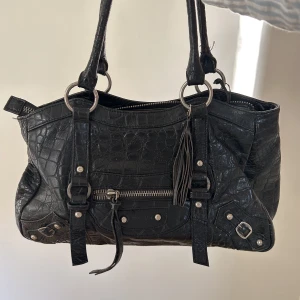 Väska  - Säljer min jättefina svarta axelväska från Stockh lm!  Rymlig väska med många gulliga detaljer 🤗❤️ Innerfodret är sönder där inne men ingenting som påverkar💕 Skriv får fler bilder eller annat 🤗  