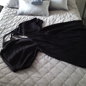 Svart sommarklänning - Svart sommarklänning i plisserat tyg. Storlek M använd ett fåtal gånger.