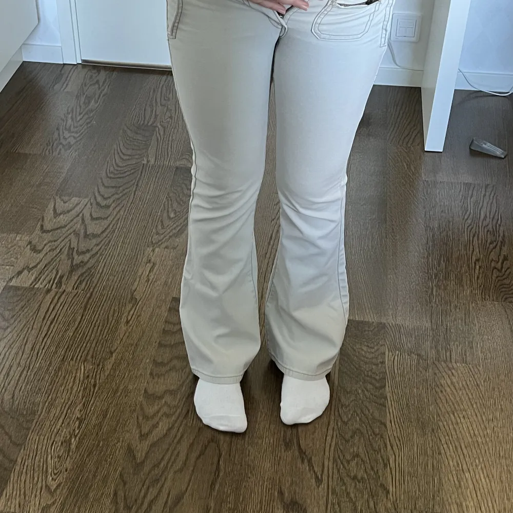 Vita / beiga lågmidjade bootcut jeans från Levi’s. Midjemått: 72 cm. Innerbenslängd: 75 cm. Hon på bilderna är 167 cm lång 💕. Jeans & Byxor.