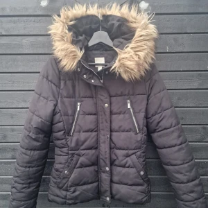vinterjacka  - En svart vinterjacka med en avtagbar pälsluva. Den är stl 38 men mer lik 36. 
