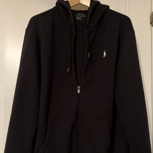 RALPH LAUREN ZIP HOODIE SVART (NYSKICK) - Säljer nu min fina Ralph lauren som är i L fast passar M perfekt! Felfri och sparsamt använd, hör av dig vid frågor och kolla gärna in våra andra annonser för fynd, MVH!