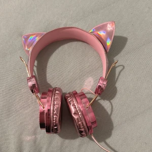Katt hörlurar  - Säljer katt hörlurar i fint skick förutom att det vänstra örat har böjts fram, men man märker inte det så mkt. Annars fint skick. Alla Diamanter e kvar, pris kan diskuteras! OBS hörlurarna är små så dom passar inte vuxna!              STÅR EJ FÖR FRAKTEN 