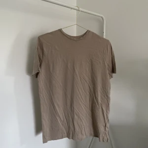 Brun/beige T-shirt  - En brun/beige T-shirt från Nelly. Storlek XS. 