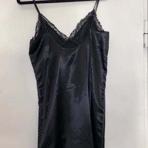 Kort satin klänning - En kort satin klänning som är öppen i ryggen med knytning där bak. Aldrig använd! Storlek: XS