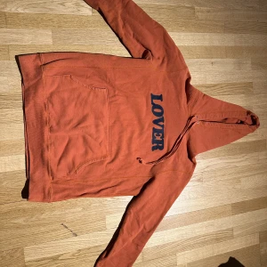 Bianca Chandon hoodie  - Bianca chandon hoodie orange med svart text, storlek L. Finns ett litet hål längst ut på höger ärm annars fint skick.   Kan skickas eller mötas upp i Göteborg.