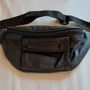 En svart magväska med fack