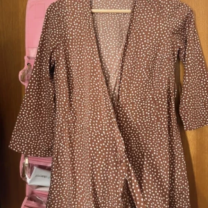 Klänning  - Brun prickig klänning som är i fint skick.