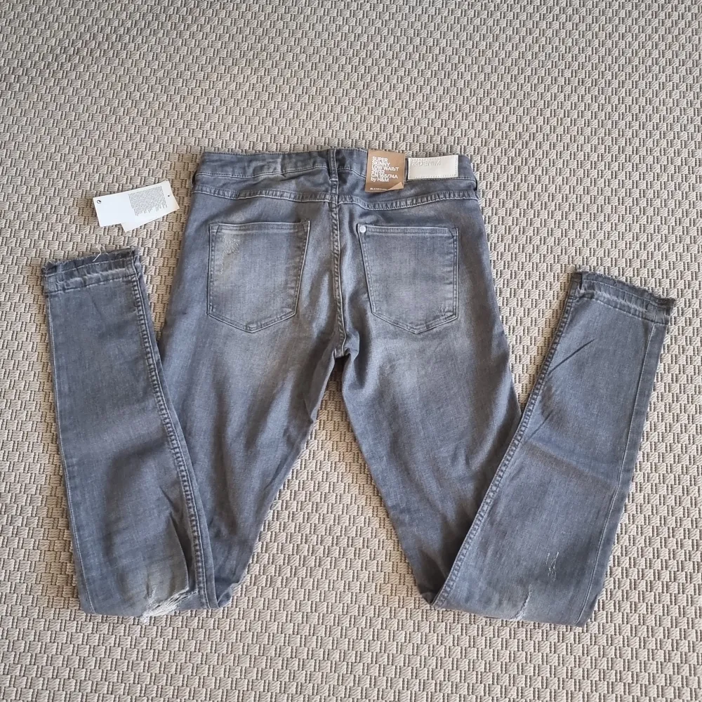 Slitna grå jeans. Super skinny low waist. Aldrig använda. . Jeans & Byxor.