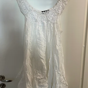 Vit klänning med virkade detaljer - Söt vit sommarklänning med virkad hals och band.