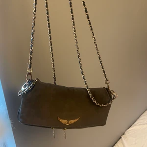 Zadig väska  - Säjer denna fina zadig väskan, den  är i ett sammet material och är grön grå i färgen, både det långa och korta bandet kommer med men bandet är lite sönder på båda banden se på bild 3 men inget man tänker på, ni står för frakt 💕priset kan diskuteras 