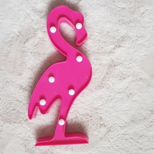 Flamingo Lampa - En Flamingo Lampa i bra skick. Det är två AA batterier som behövs. Det ingår två AA batterier när du köper denna. Man kan även hänga upp denna på väggen då det finns ett hål på baksidan som gör detta möjligt. Måtten är längd 30 cm. Bredd ca 11 cm.  