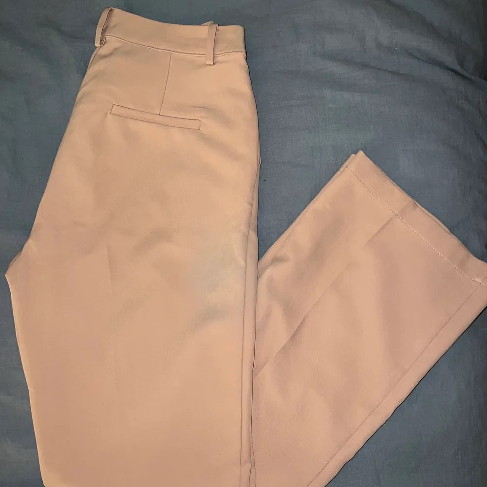 Beige/rosa kostymbyxor från Bikbok. Köpt för ca 3 år sedan. Stretchiga med en rak passform. Storlek 38. Jeans & Byxor.