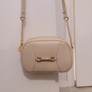Väska - Beige väska med guldiga detaljer. Knappt använd, hel och fin. 