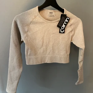 Aimn Ribbed seamless crop long sleeve - Beige croppad träningströja. Aldrig använd med lapp kvar. Nypris 499 kr.