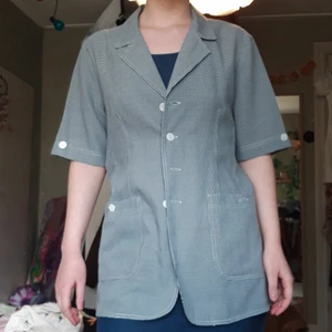 Kortärmad kavaj - Tunn kortärmad boxig kavaj med två fickor fram. Vit och svartmönstrad. 