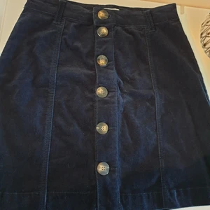 Marinblå kjol - Marinblå kjol med knappar. Tyget påminner om manchester. Helt oanvänd. Passar xs/s. 