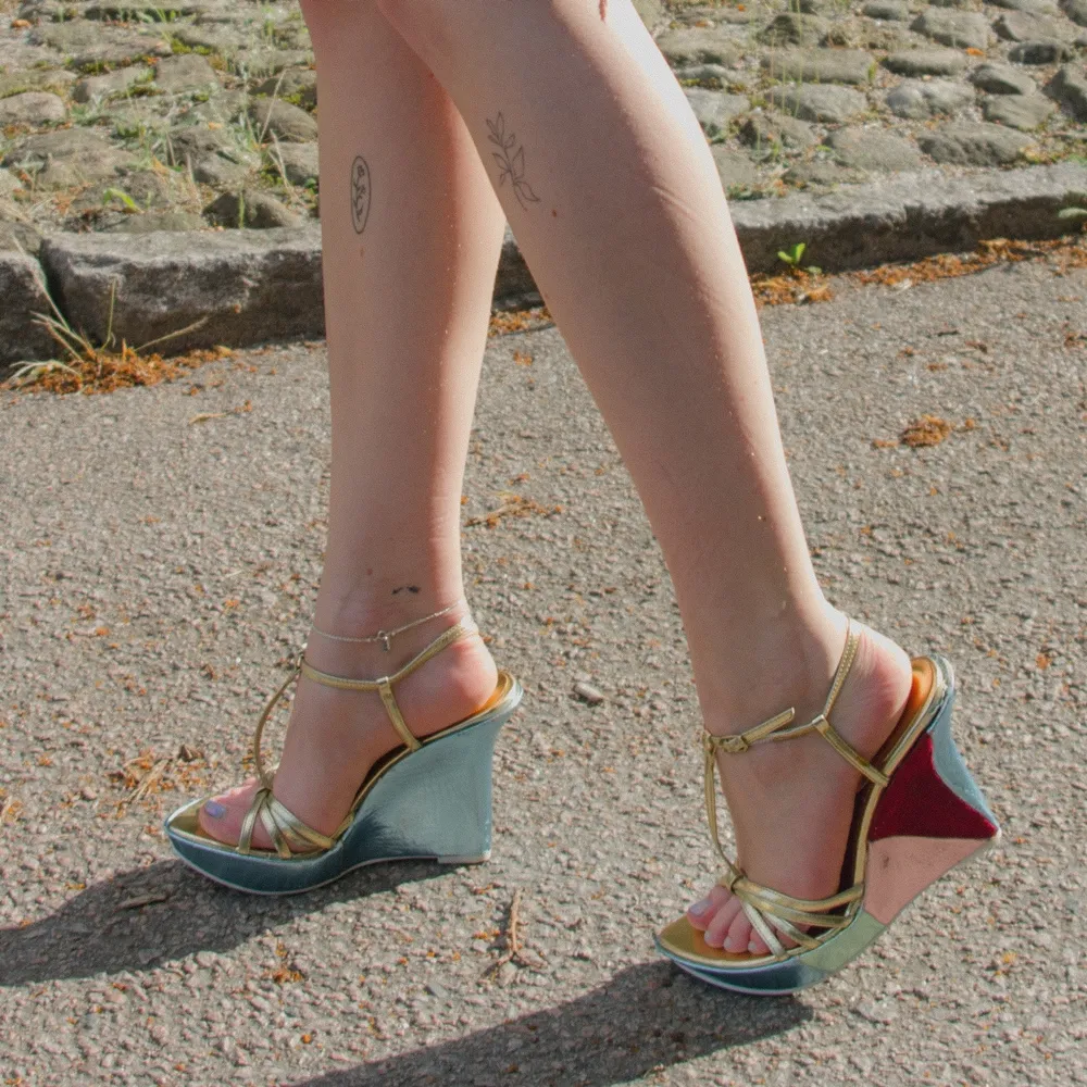 Dösnygga klackskor med kilklack. Skorna är i skimrande pastellfärger och sammetsrött med guldfärgade band. De är i använt skick men stör inte auran som kommer med dessa skor 😛 de är små i storleken så 36, 36,5 är optimal storlek. . Skor.