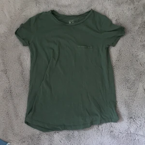 Grön T-shirt  - En grön T-shirt med en fake ficka över det vänstra bröstet. Tröjan är i väldigt bra skick då jag har använt den ett fåtal gånger. 