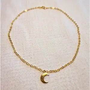 Guldfärgat halsband med måne 🌙 Kedjan är ca 40 cm lång, och passformen går att justera. Skickas i vadderat kuvert via postnord. 