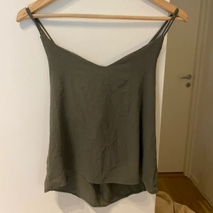 Grönt Linne - Fint grönt linne med korsad rygg! Använd men är i fint skick. Strl S
