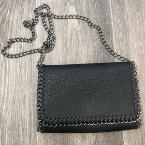 Svart väska - Svart axelbandsväska med två innerfickor. I gott skick. Perfekt till fester osv. Frakt på 24kr tillkommer. Budgivning startad, avslutas lördag 18.00, minst 10kr mellan varje🌷