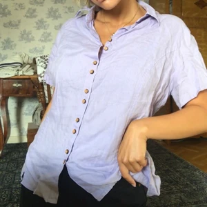 Lila linneskjorta - Så härlig lila vintage linneskjorta (100% linne!) med unika träknappar🥰 Går att knyta i ryggen! Köpt secondhand men knappt använd av mig så i fint skick💞💞