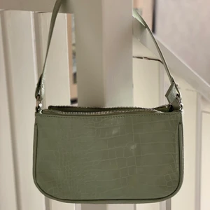 Grön väska  - En fin grön väska med ett innefack och ett avtagbart längre band, se bild nr 2 för bättre bild på färgen. Frakten är inräknat i priset