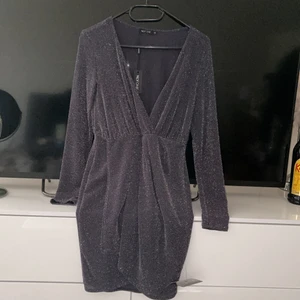 Jättefin klänning från Nelly  - Klänningen är i färgen grå med silvertråd. Storlek XS