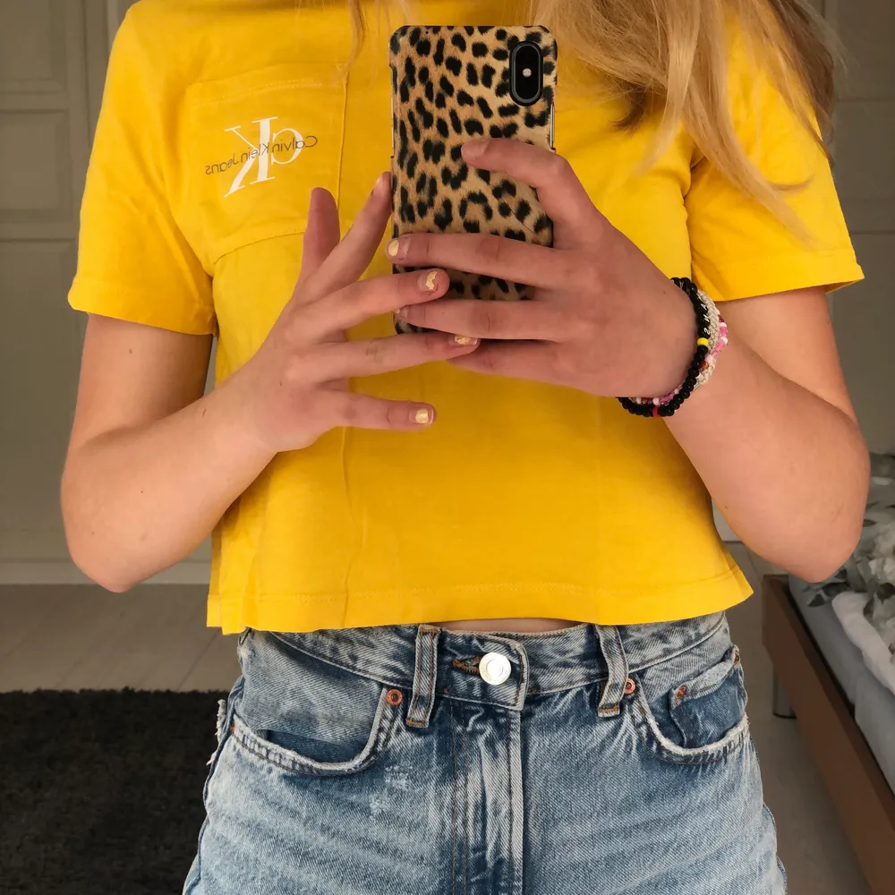 En gul Calvin Klein T-shirt i en kort modell.     Storleken S. . T-shirts.