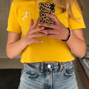 En gul Calvin Klein T-shirt i en kort modell.     Storleken S. 